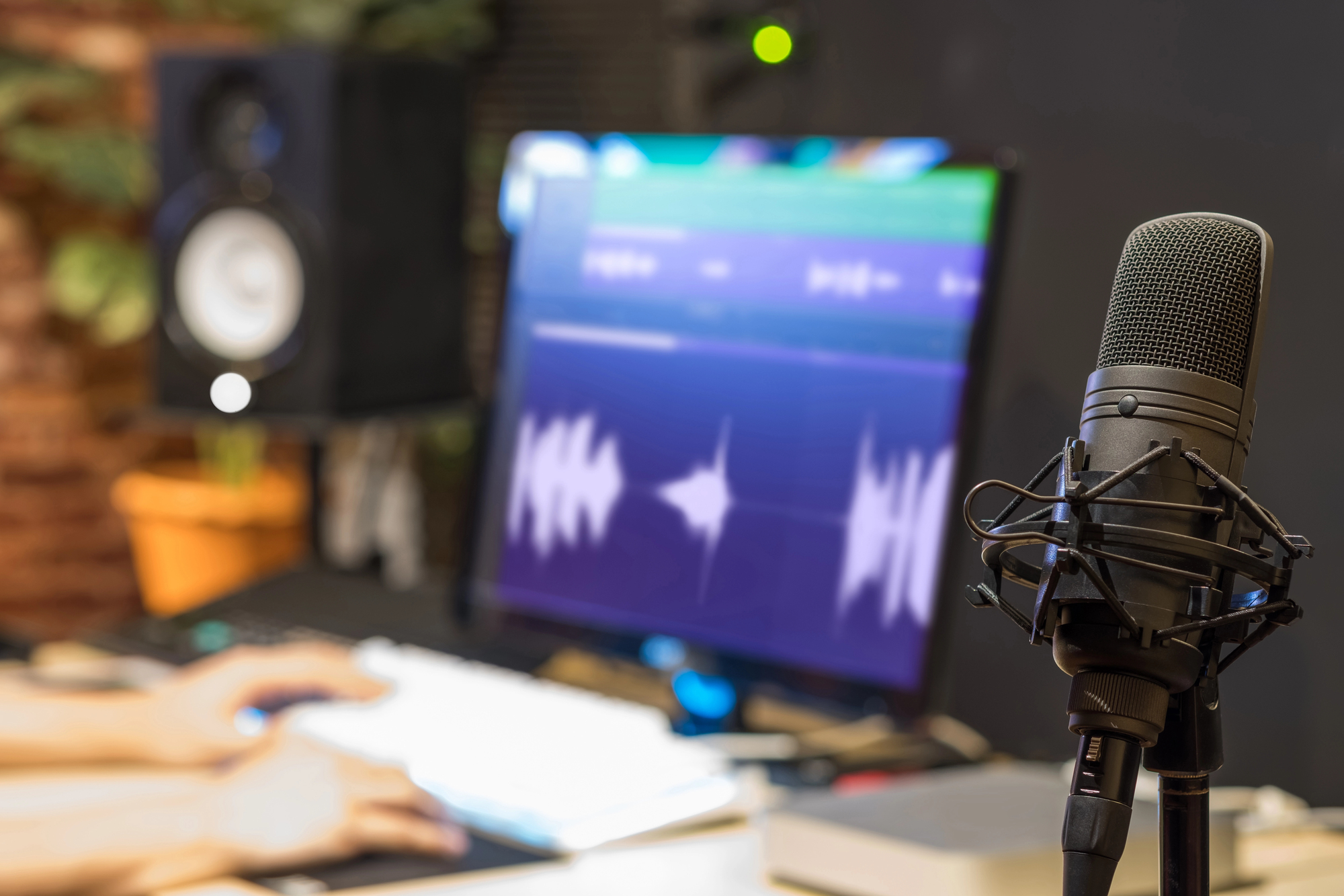 Microphone de studio devant un écran affichant une onde sonore