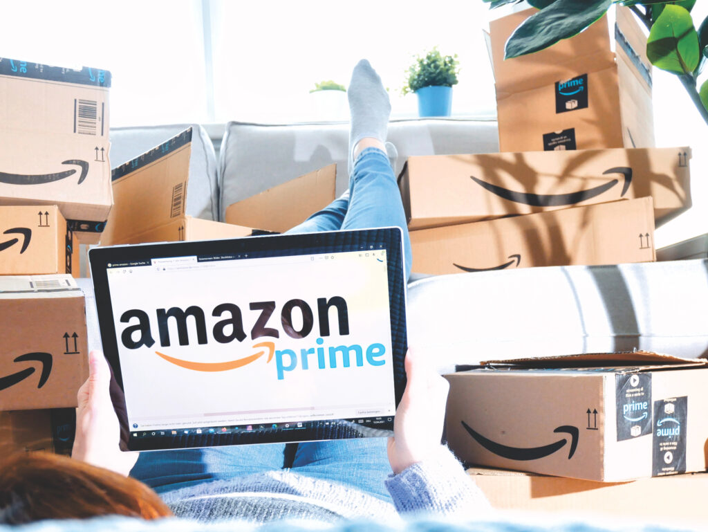 Utilisateur de tablette entouré de nombreux colis Amazon Prime.