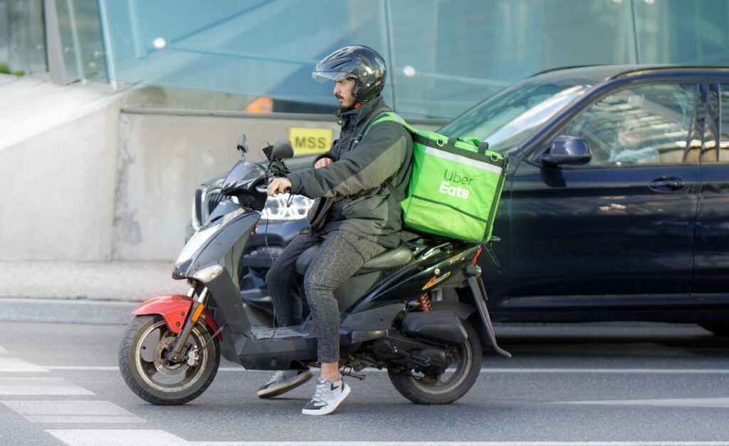 Livreur Uber Eats sur un scooter noir en ville