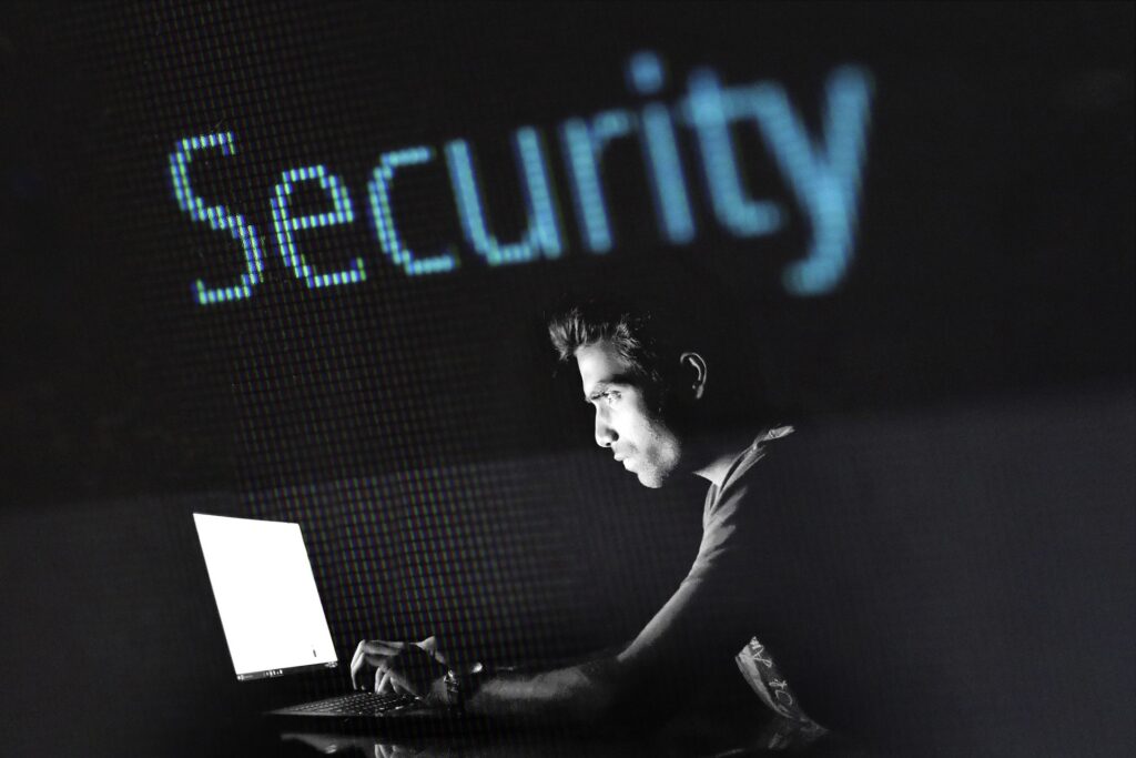 Homme devant un ordinateur sous le mot "Security" lumineux.