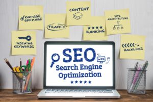 Ordinateur affichant « SEO » entouré de notes autocollantes