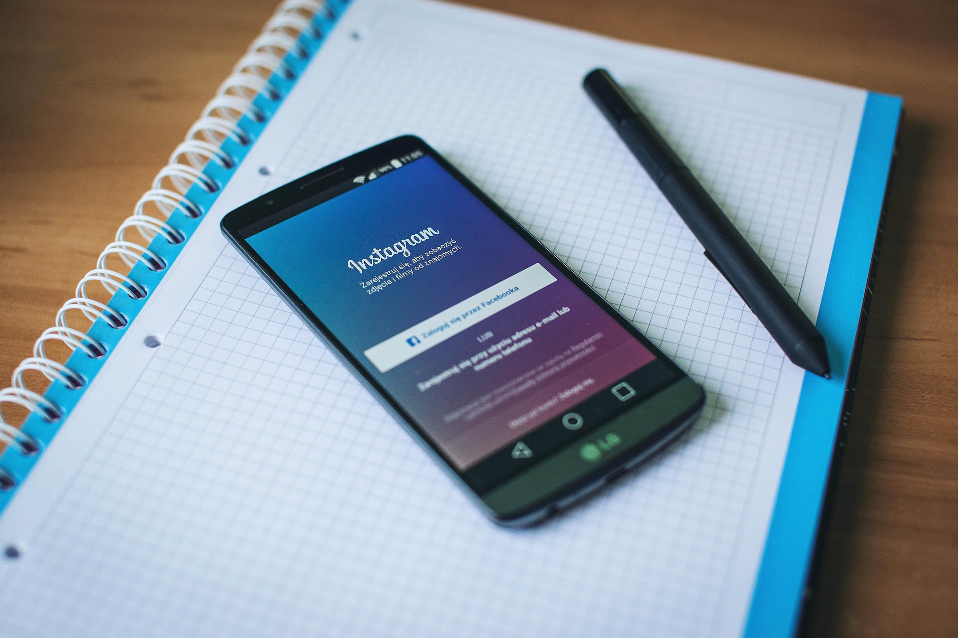 Logo Instagram sur smartphone posé devant un clavier d'ordinateur.